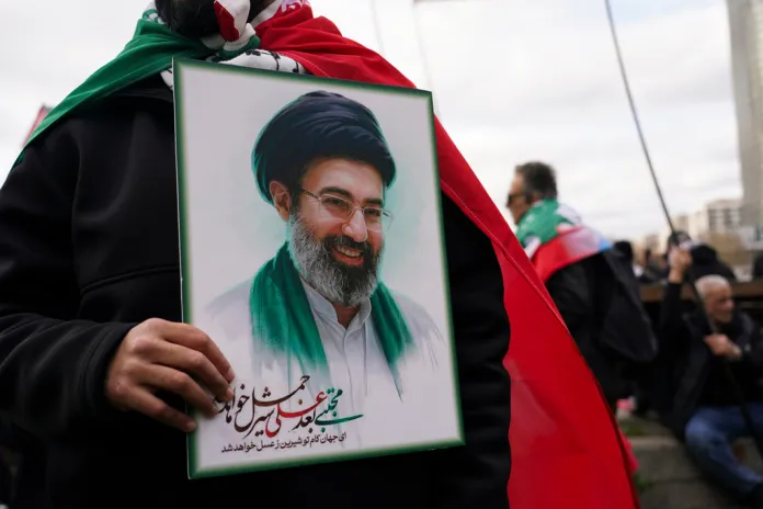 A demonstrator holds a portrait of Iranian Ayatollah Mojtaba Khamenei.
