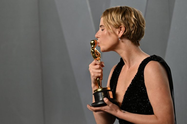 Jessie Buckley kisses an Oscar award at the Vanity Fair Oscar Party.