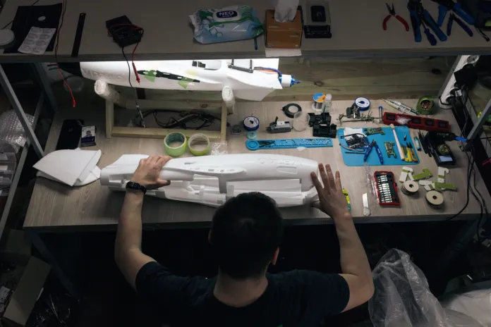 A Ukrainian soldier tinkers with drones in a military workshop