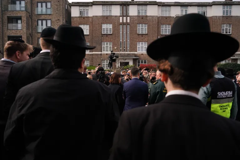 People gather to listen to Britain's Secretary of State for Health and Social Care Wes Streeting.