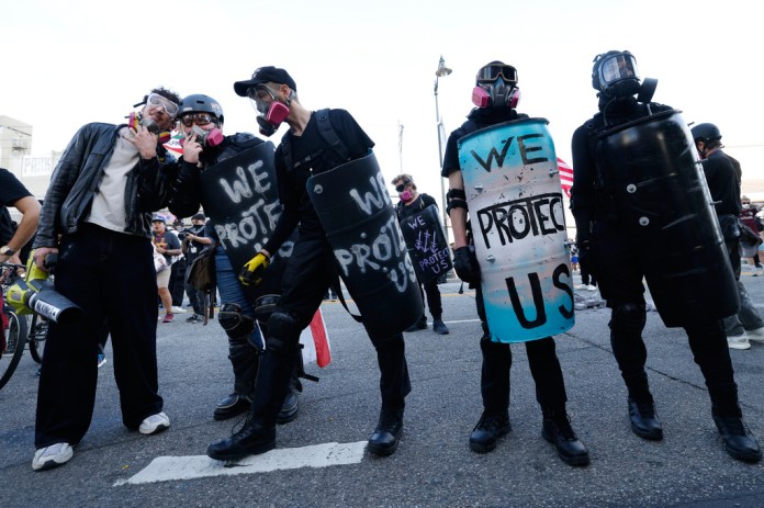 Protesters stand off against police outside the Metropolitan Detention Center in downtown Los Angeles during a "No Kings" rally Saturday, March 28, 2026.