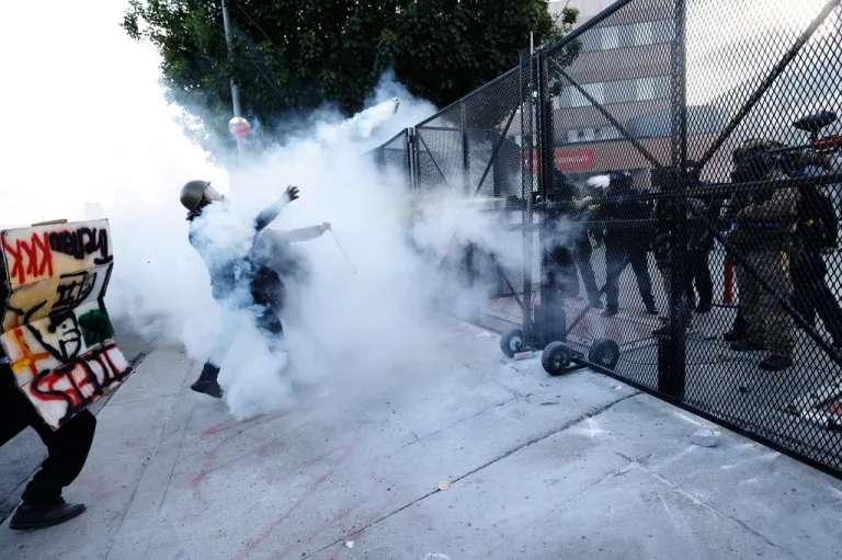 Protesters face off against police firing tear gas outside the Metropolitan Detention Center in downtown Los Angeles.
