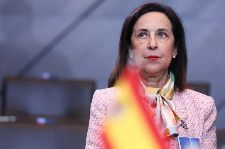 Margarita Robles stands behind a Spanish flag