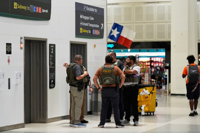 ICE officers stand near TSA security lines at George Bush Intercontinental Airport on Monday, March 30