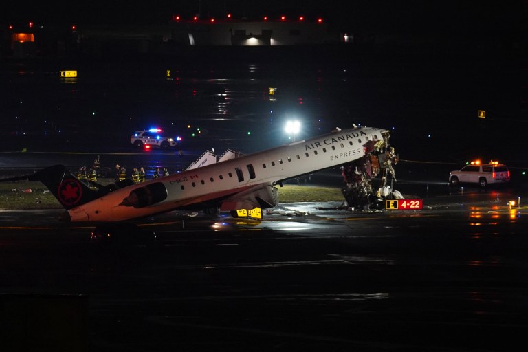 An Air Canada jet sits on the runway at LaGuardia Airport, Monday, March 23, 2026, after colliding with a Port Authority aircraft rescue and firefighting vehicle in New York. (AP Photo/Ryan Murphy)