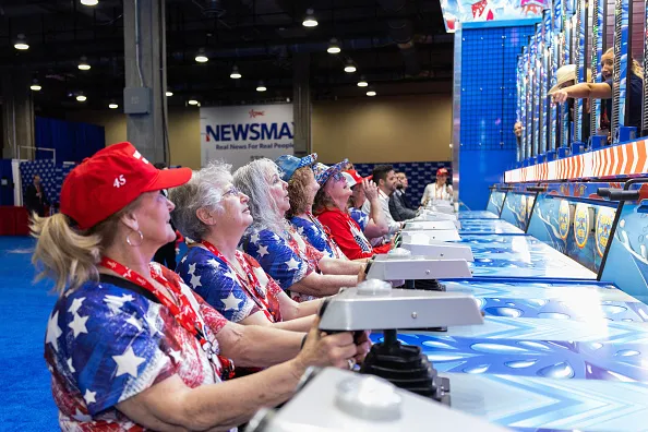 A group of women clad in American-themed attire play interactive games during the Conservative Political Action Conference (CPAC) in Grapevine, Texas, on March 27, 2026. American conservatives converge on Texas this week for what organizers bill as their largest and most influential gathering, with the Iran war and fears of a punishing midterm election cycle heightening the stakes.