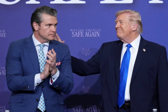 President Donald Trump speaks with Defense Secretary Pete Hegseth during a roundtable discussion on public safety at a Tennessee Air National Guard Base, Monday, March 23, 2026, in Memphis, Tenn. (AP Photo/Mark Schiefelbein)