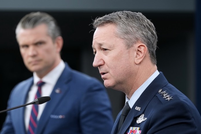 Defense Secretary Pete Hegseth listens to Chairman of the Joint Chiefs of Staff Gen. Dan Caine, during a press briefing at the Pentagon, Monday, March 2, 2026, in Washington. (AP Photo/Mark Schiefelbein)