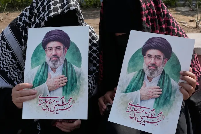 Women hold posters of the Iranian Supreme Leader Ayatollah Mojtaba Khamenei during a campaign in support of the government at the Enqelab-e-Eslami, or Islamic Revolution, square in downtown Tehran, Iran, Saturday, March 14, 2026. (AP Photo/Vahid Salemi)