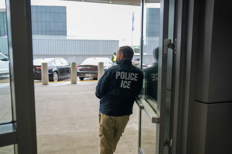 A U.S. Immigration and Customs Enforcement agent stands at John F. Kennedy International Airport