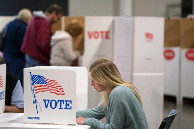 A woman votes with others at a Edmond, Okla., church Tuesday, Nov. 8, 2016. Officials at the site report that 40% of the registered voters had voted today.
