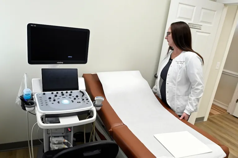 Portico Crisis Pregnancy Center nurse manager Diandra Bell straightens an examination table.