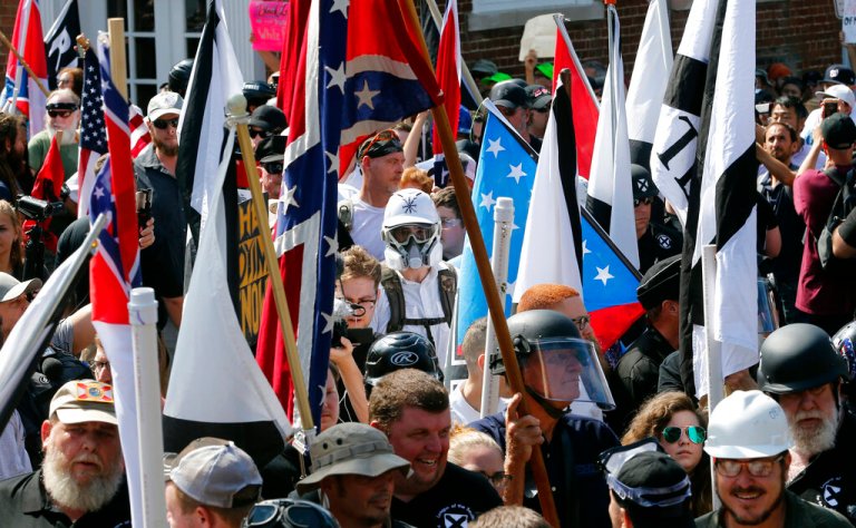 White nationalist demonstrators walk into the entrance of Lee Park surrounded by counter demonstrators on Aug. 12, 2017, in Charlottesville, Va.