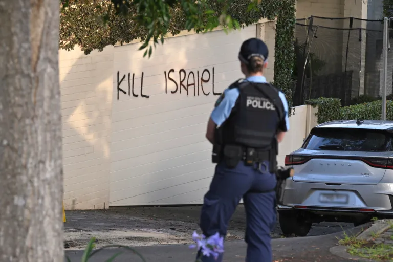 A police officer stands near where anti-Israel graffiti is painted on a wall in Sydney, Australia, on Dec. 11, 2024.