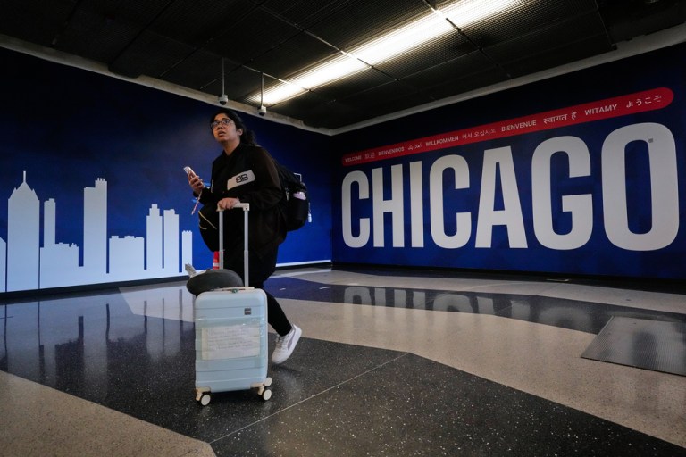 A traveler walks though the terminal at O'Hare airport in Chicago, Tuesday, Dec. 23, 2025. (AP Photo/Nam Y. Huh)