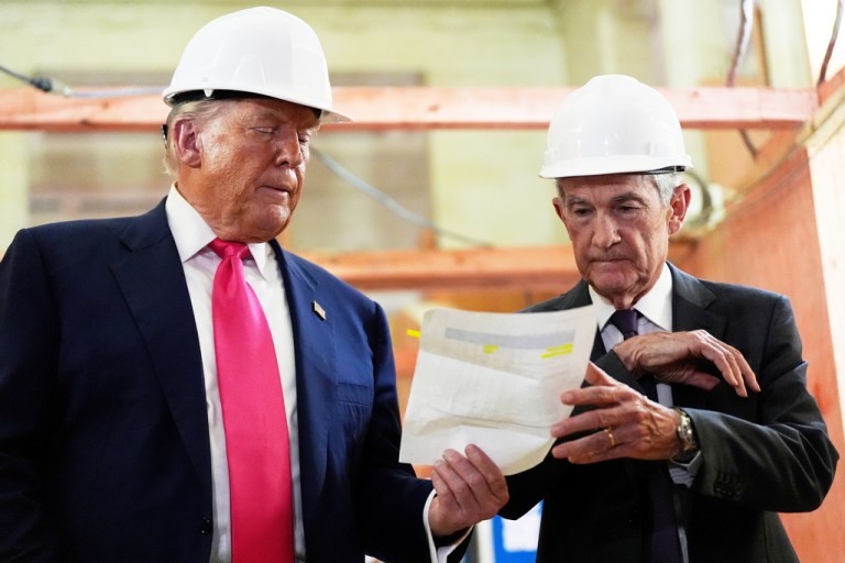 Federal Reserve Chairman Jerome Powell, right, and President Donald Trump look over a document of cost figures during a visit to the Federal Reserve, July 24, 2025, in Washington.