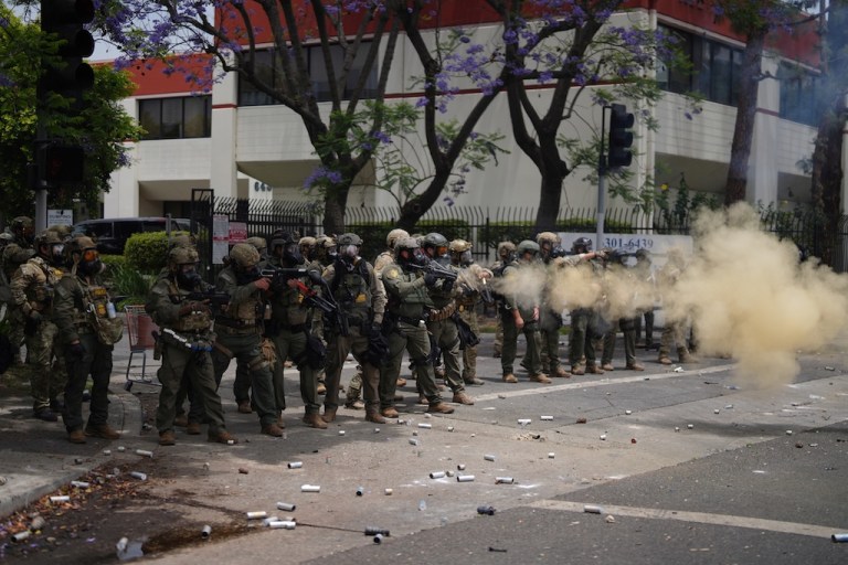 Border Patrol personnel deploy tear gas.