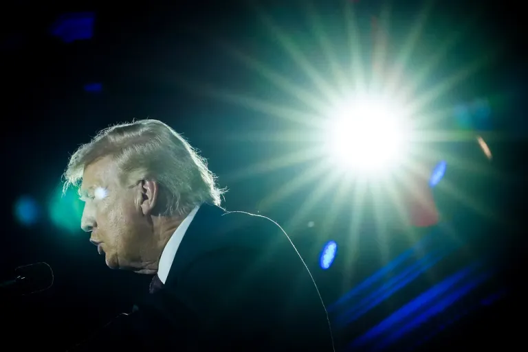 Big glare of light on the right of the image, and President Donald Trump, left, speaks at the National Republican Congressional Committee's annual fundraising dinner, Wednesday, March 25, 2026