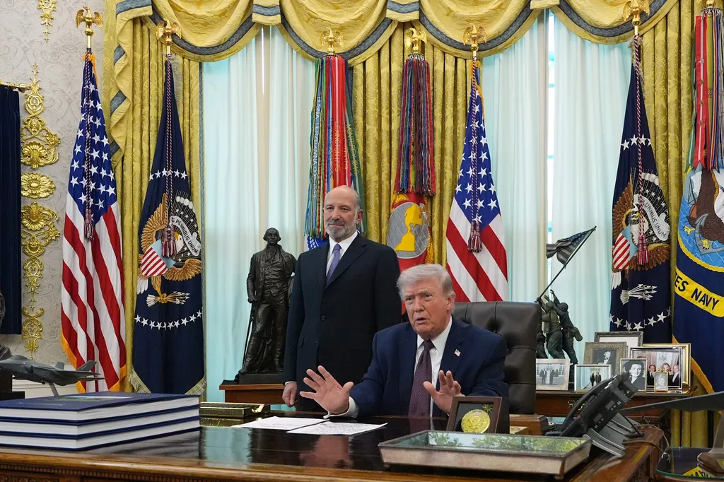 President Donald Trump answers questions from reporters after signing an executive order in the Oval Office of the White House, Tuesday, March 31, 2026, in Washington, as Commerce Secretary Howard Lutnick listens. (AP Photo/Alex Brandon)