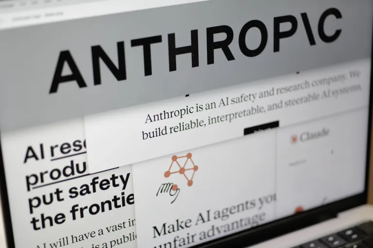 Pages from the Anthropic website and the company's logo are displayed on a computer screen.