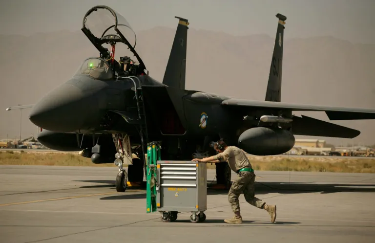 FILE - A U.S. Air Force airman pushes a cart past an F-15E Strike Eagle at Bagram Air Field in Afghanistan on Oct. 17, 2009.