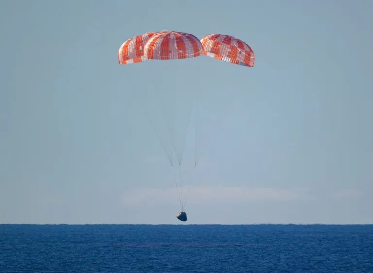 In this photo provided by NASA, the Orion spacecraft with Artemis II crewmembers aboard approaches the surface of the Pacific Ocean for splashdown off the coast of California, Friday, April 10, 2026. (Bill Ingalls/NASA via AP)
