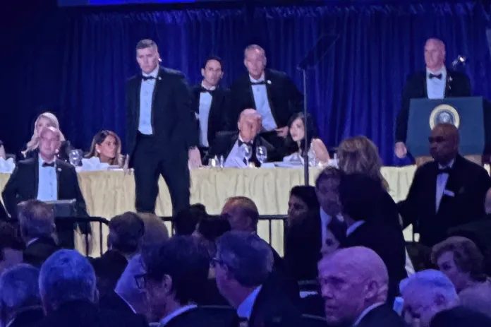 U.S. Secret Service agents surround President Donald Trump before he was taken from the stage after a shooting incident outside the ballroom during the White House Correspondents Dinner, Saturday, April 25, 2026, in Washington. 
