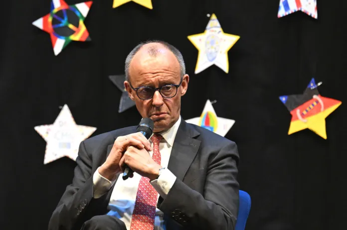 Friedrich Merz sits in front of star decorations.