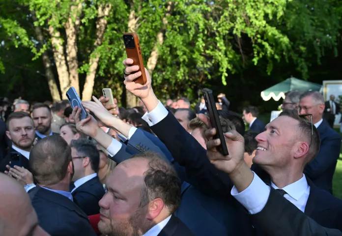 People watch as Britain's King Charles III speaks with guests during a garden party at the British Embassy, Monday, April 27, 2026, in Washington. 