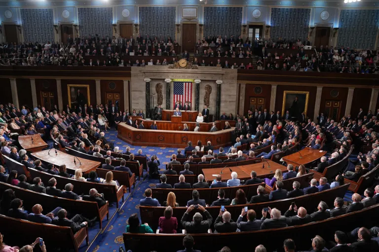 Wide shot of the Congressional floor as Charles speaks