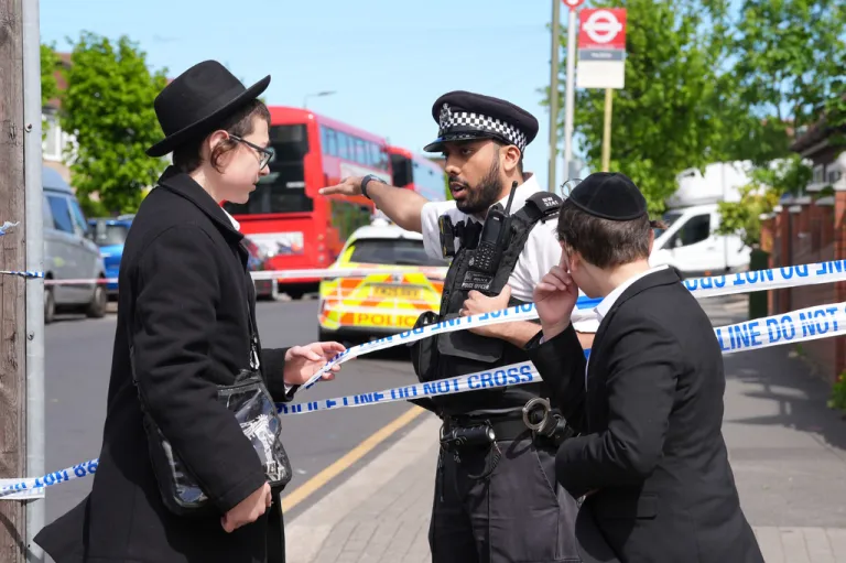 Police speak with people in London.