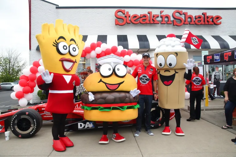 The No. 15 Steak 'n Shake Indy car driver Graham Rahal poses with Steak 'n Shake mascots Goldie, Sizzle and Shaker on Thursday, May 14, 2015