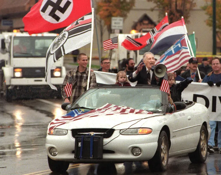 In this Oct. 28, 2000, file photo, white supremacist Richard Butler, speaks through a megaphone at an Aryan Nations rally in Coeur d'Alene, Idaho. The Aryan Nations is long gone from northern Idaho, but its reputation lingers to the chagrin of locals. (AP Photo/Tom Davenport, File)