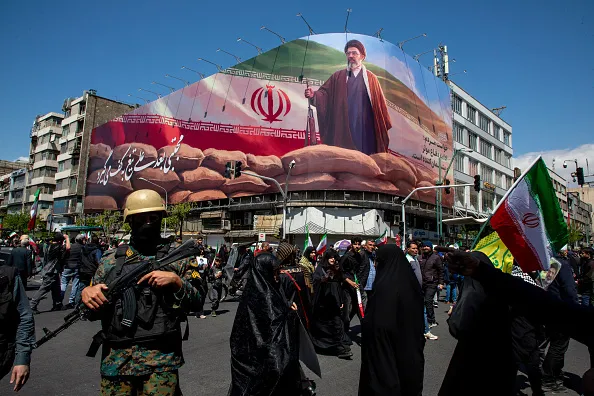 People gather under a large portrait of Iran's new Supreme Leader, Mojtaba Khamenei, during a memorial to mark the 40th day since his father, Ali Ayatollah Khamenei, was killed in US-Israeli joint strikes, on April 9, 2026 in Tehran, Iran. On April 8 President Donald Trump announced a two-week ceasefire between the US and Iran, conditional on shipping being allowed to resume through the Strait of Hormuz.