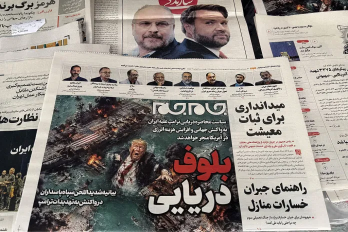 The front page of the Jam Jam newspaper on sale at a newsstand features a cartoon of US President Donald Trump drowning in the Strait of Hormuz with the headline "Marine Bluff" in Tehran on April 13, 2026. The failure of US-Iran peace talks has left the US President with several unpalatable options, as analysts say his order to blockade the strategic Strait of Hormuz could further complicate his next move on April 12, 2026. Any hopes that US Vice President would emerge from the marathon day of negotiations with top Iranian officials with a deal to end a war that has rippled across the Middle East were dashed when he left hosts Pakistan emptyhanded. (Photo by ATTA KENARE / AFP via Getty Images) /