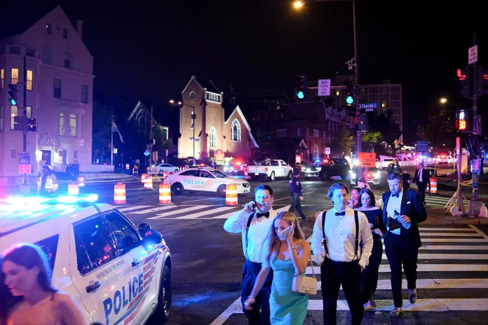 Guests walk away from the Washington Hilton amid a heavy police presence after shots were heard during the White House Correspondents' Dinner in Washington, DC, on April 25, 2026. Shots were fired as US President Donald Trump attended a press dinner in Washington on April 25 night, witnesses and AFP reporters confirmed. Loud bangs were heard and guests at the black-tie White House Correspondents' Dinner scrambled to hide under tables. Tactical teams with guns drawn took position on the stage where Trump had been sitting before he was evacuated. (Photo by Ulysse BELLIER / AFP via Getty Images)