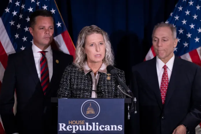 Rep. Jen Kiggans, R-Va., center, accompanied by Rep. Zachary Nunn, R-Iowa, left, and House Majority Leader Steve Scalise, R-La., right, speaks at a news conference at the Republican National Committee headquarters on Capitol Hill in Washington, Wednesday, Sept. 18, 2024. (AP Photo/Ben Curtis)