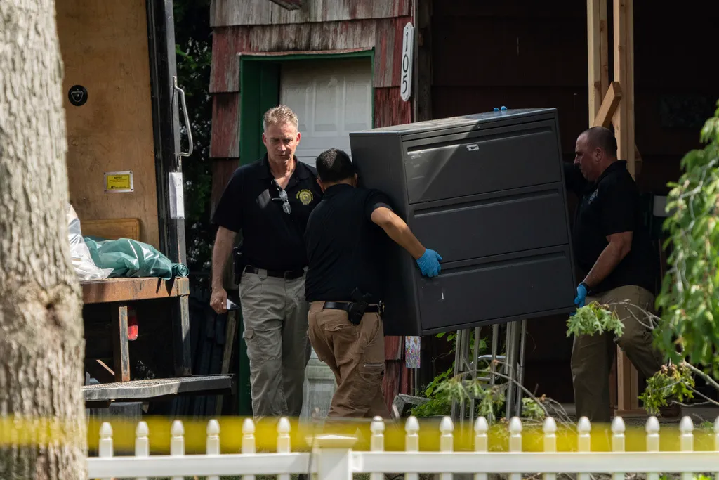 New York State police officers move a metal cabinet as law enforcement searches the home of suspected serial killer Rex Heuermann, Saturday, July 15, 2023, in Massapequa Park, N.Y. As new details emerge about how police finally caught the alleged killer, they've also raised questions about whether investigators adequately pursued a key lead that may have helped solve the case sooner. (AP Photo/Jeenah Moon, File)
