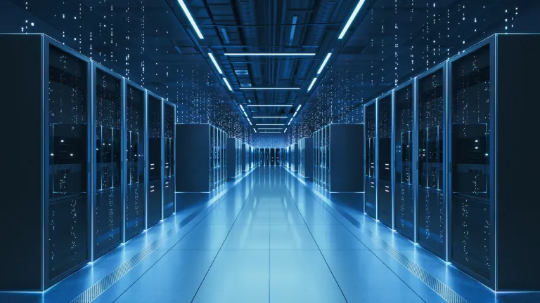 Interior view of a futuristic data center designed for artificial intelligence processing, featuring glowing servers and digital data streams.