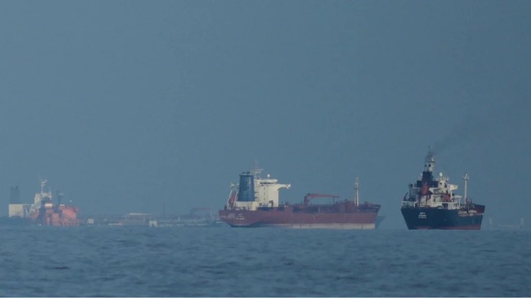Oil tankers and cargo ships line up in the Strait of Hormuz as seen from Khor Fakkan, United Arab Emirates.