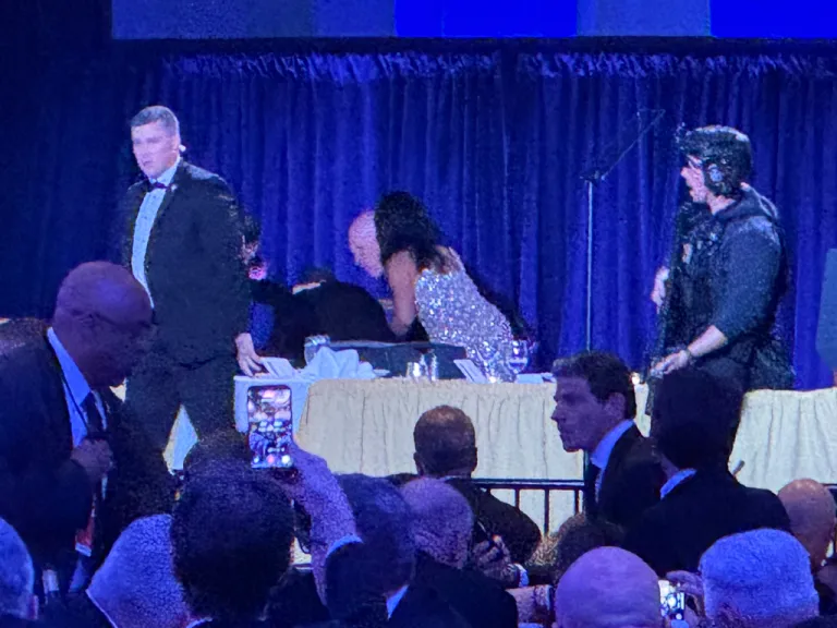 U.S. Secret Service agents surround President Donald Trump as he is taken from the stage after a shooting incident outside the ballroom during the White House Correspondents Dinner.