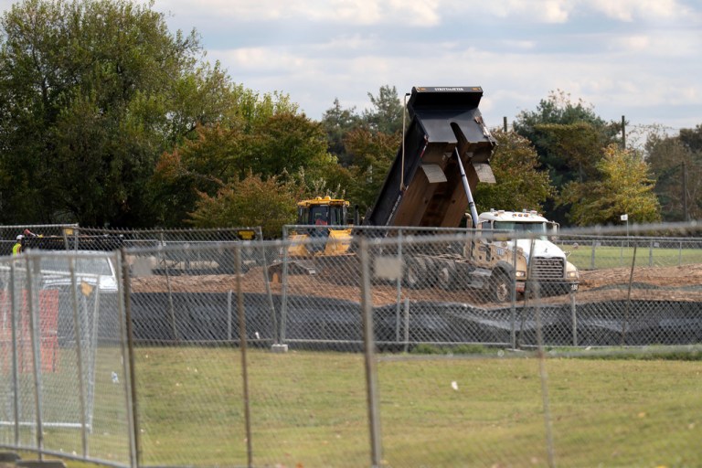 Truck dumping dirt next to east potomac golf links
