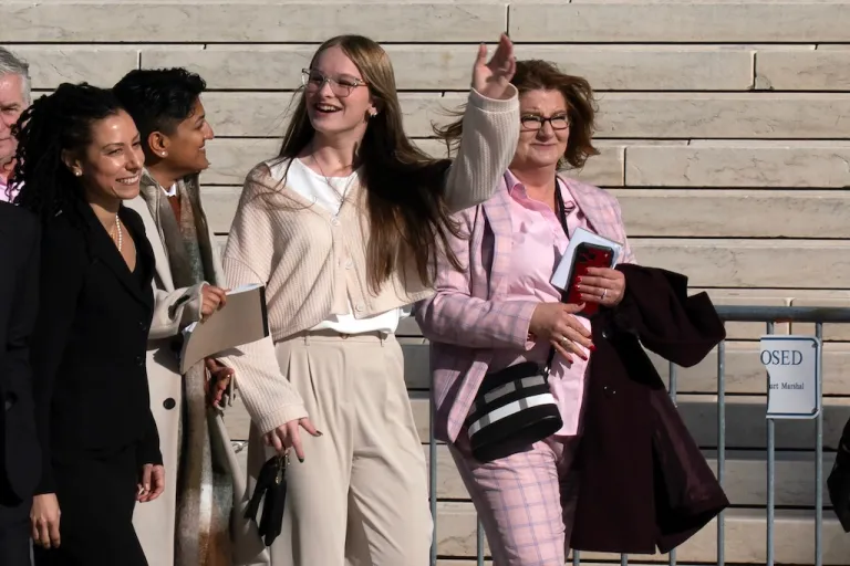Becky Pepper-Jackson, center, accompanied by mother Heather Jackson, right, waves to the crowd as they walk to meet reporters after the Supreme Court heard arguments over state laws barring biological men from playing on women's school athletic teams, Tuesday, Jan. 13, 2026, in Washington. (AP Photo/Jose Luis Magana)