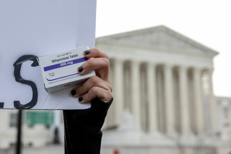 A pro-abortion activist holds a box of mifepristone pills as demonstrators from both anti-abortion and pro-abortion groups rally outside the Supreme Court in Washington, March 26, 2024. (AP Photo/Amanda Andrade-Rhoades, File)