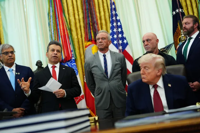 Dr. Marty Makary, commissioner of the Food and Drug Administration, speaks while, from left, National Institutes of Health Director Dr. Jay Bhattacharya, Health and Human Services Secretary Robert F. Kennedy Jr., Joe Rogan, President Donald Trump, Joe Rogan and CEO of Americans for Ibogaine W. Bryan Hubbard listen in the Oval Office of the White House, Saturday, April 18, 2026, in Washington. (AP Photo/Julia Demaree Nikhinson)