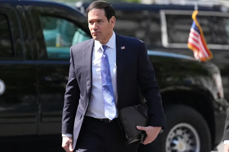 Marco Rubio walking in front of a vehicle at the White House.