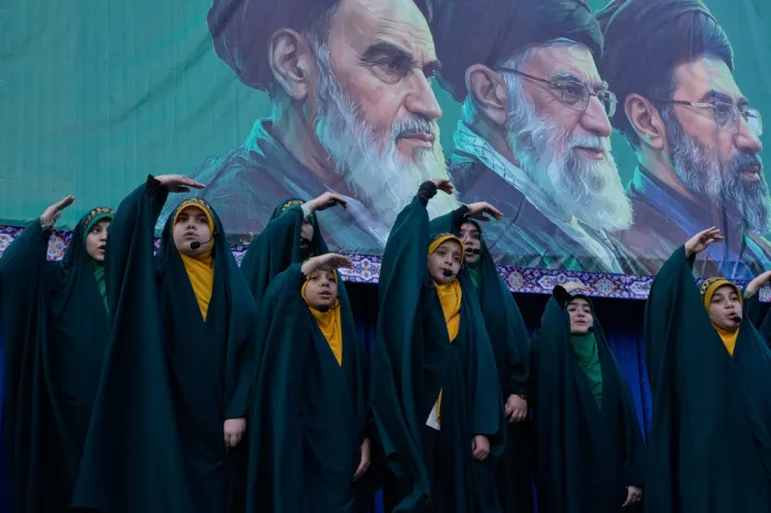 Children sing in front of portraits of ayatollahs