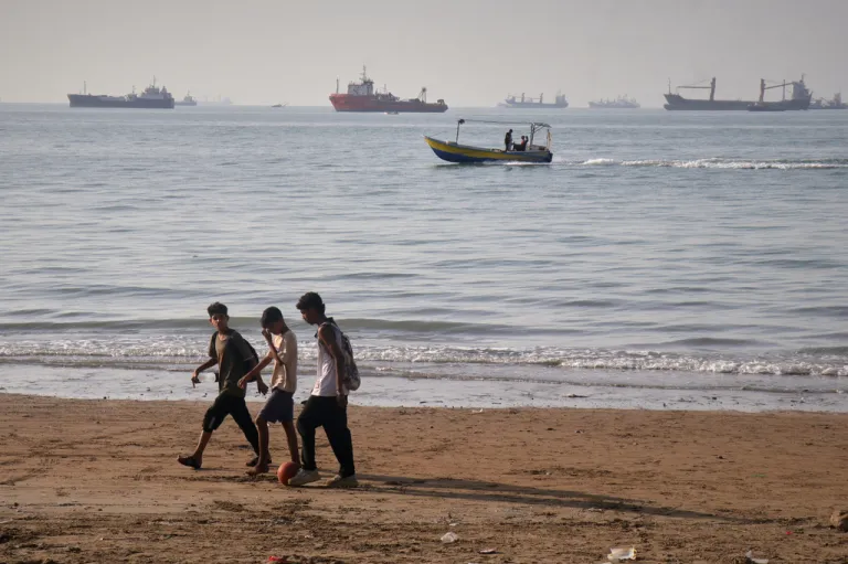 Children walk past the Strait of Hormuz.