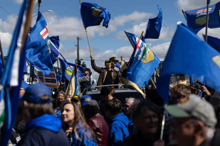 Supporters fly flags in support of Mitch Sylvestre as he submits his signatures for a separation referendum to Elections Alberta in Edmonton, on Monday, May 4, 2026.