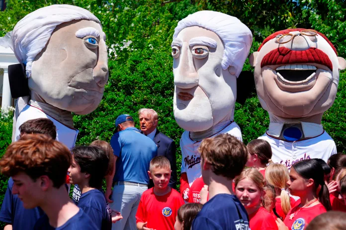 President Donald Trump and Bryson DeChambeau speak, alongside mascots of the Washington Nationals baseball team, as kids get ready to partake in exercises at fitness stations on the south lawn of the White House, Tuesday, May 5, 2026, in Washington.